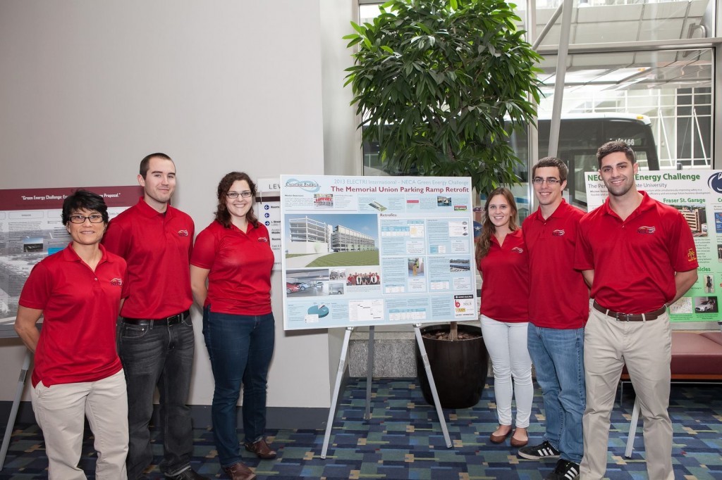 The 2013 presenting team stands by their poster, which gives a visual outline of their proposal. 